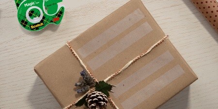 Creando etiquetas de regalo usando Cinta Scotch® Magic™ en un regalo envuelto
