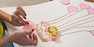 Niña creando obras de arte con cinta adhesiva Scotch® de doble cara
