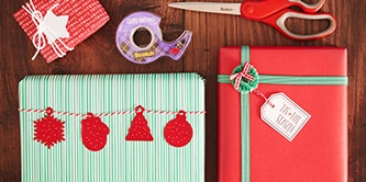 Crear un aspecto tradicional de envoltorio de regalo navideño con colores rojo, verde y blanco, y adherir figuras de papel con Cinta de Doble Cara Scotch®
