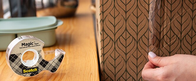 La cinta Scotch® Magic™ con un 66 % de adhesivo de origen vegetal, para fijar una caja
