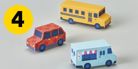 Paso 4 - tres coches de papel sobre una mesa
