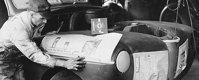 Imagen en blanco y negro de un hombre con cinta de enmascarar y no dañar pintura de coche
